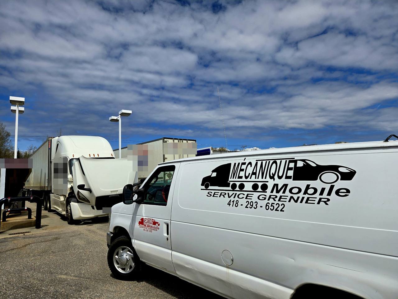Camion lourd avec le capot ouvert à côté de la fourgonnette de service